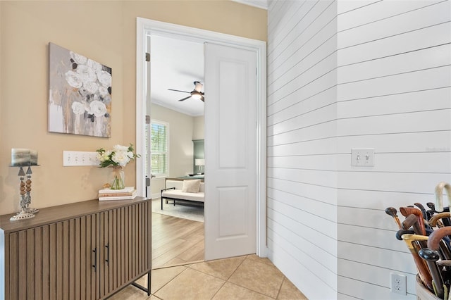 hallway with crown molding and light tile patterned floors