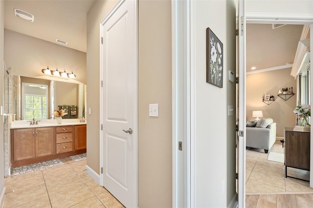 bathroom with tile patterned flooring, vanity, and ornamental molding