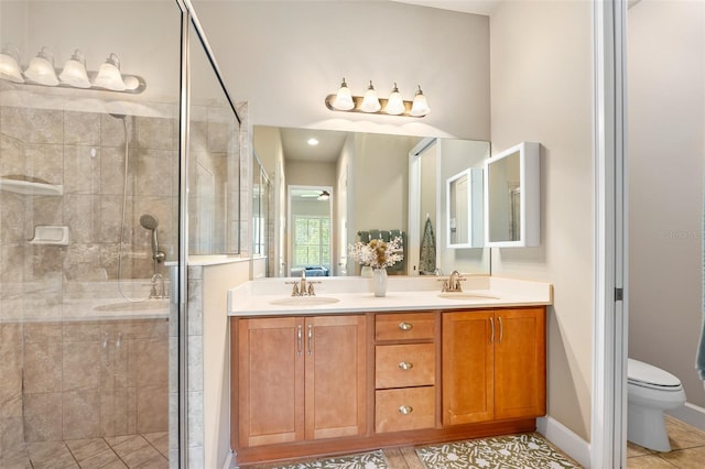 bathroom with vanity, tile patterned floors, a shower with door, and toilet