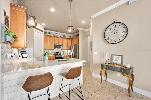 kitchen featuring pendant lighting, appliances with stainless steel finishes, kitchen peninsula, and sink