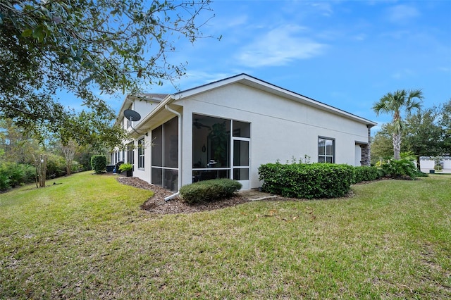 view of home's exterior with a yard and a sunroom