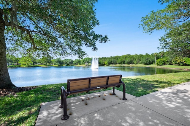 view of home's community with a water view and a yard