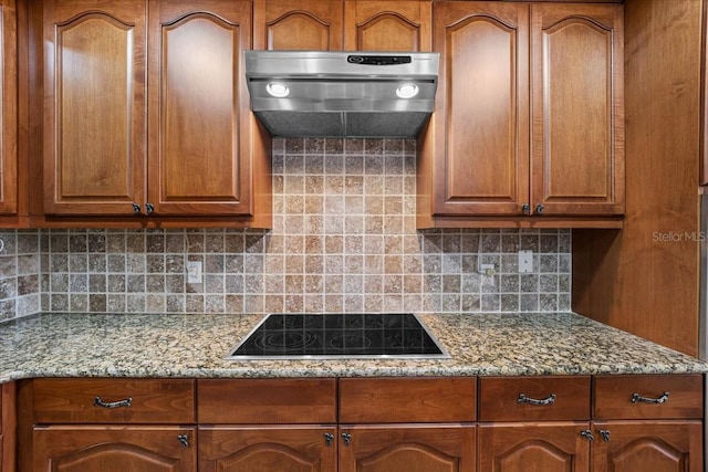 kitchen with ventilation hood, light stone countertops, backsplash, and black electric cooktop