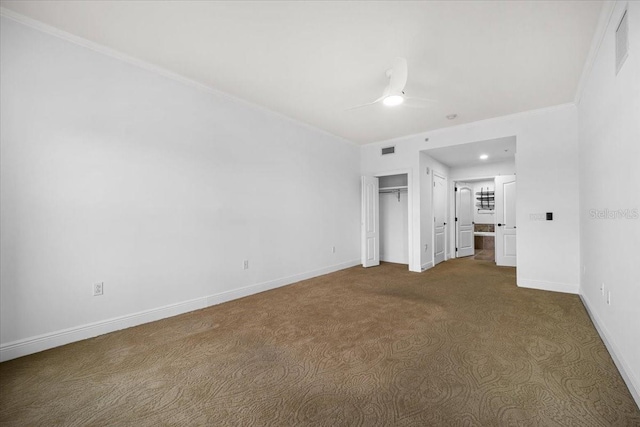 unfurnished bedroom featuring crown molding, carpet floors, ceiling fan, and a closet