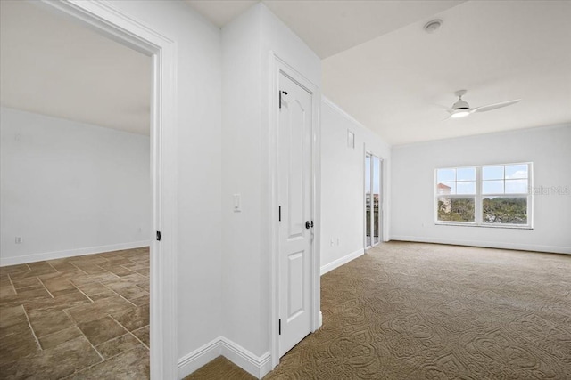 hall with dark colored carpet