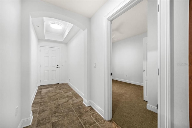 hall featuring a raised ceiling