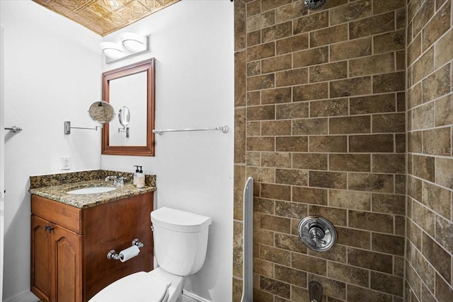 bathroom with vanity, toilet, and a tile shower