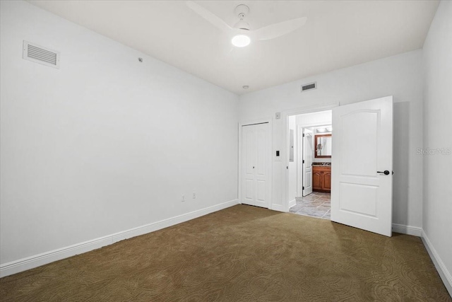 unfurnished bedroom with carpet floors, connected bathroom, ceiling fan, and a closet