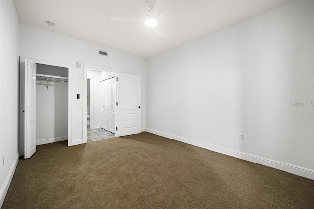 unfurnished bedroom with ceiling fan, a closet, and dark colored carpet