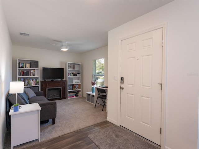 living room featuring dark hardwood / wood-style flooring and ceiling fan