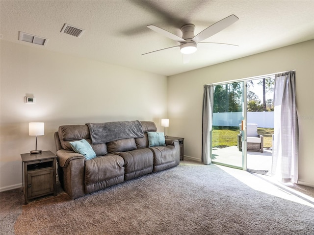 living room with ceiling fan, carpet, and a textured ceiling