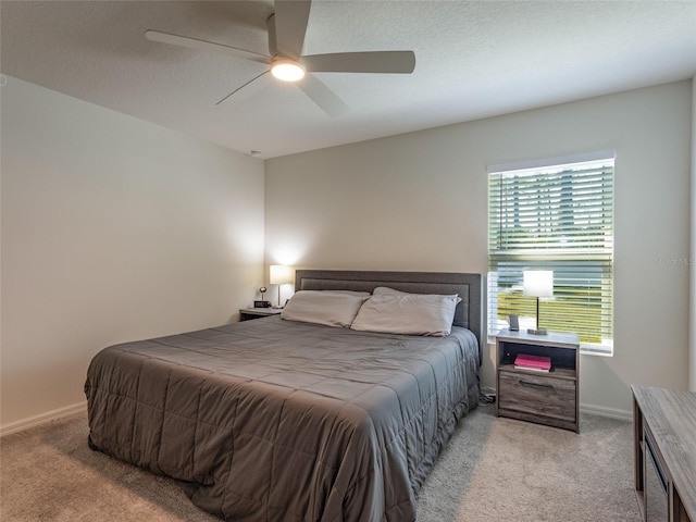 carpeted bedroom with ceiling fan and a textured ceiling