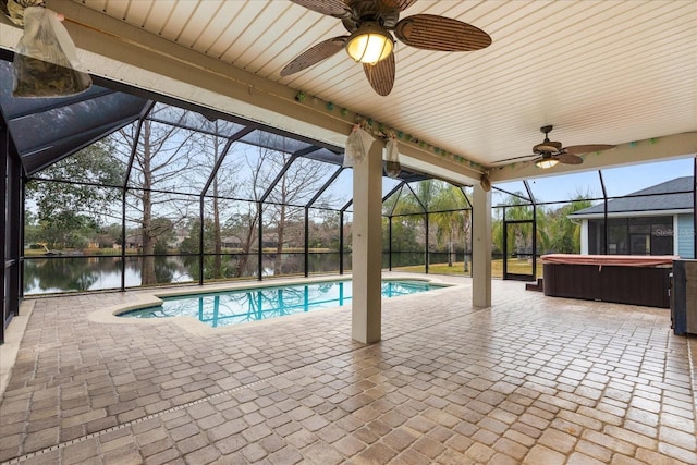 view of swimming pool featuring ceiling fan, glass enclosure, a water view, a patio area, and a hot tub