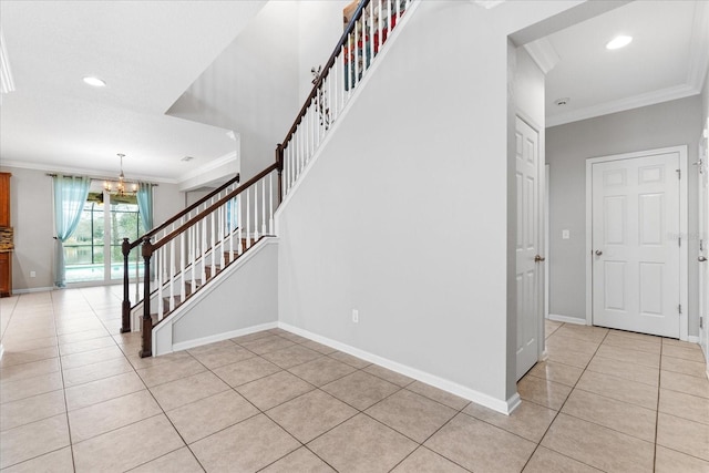 stairs with a notable chandelier, crown molding, and tile patterned floors