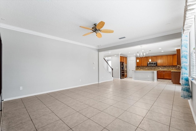 unfurnished living room with crown molding, ceiling fan with notable chandelier, and light tile patterned floors