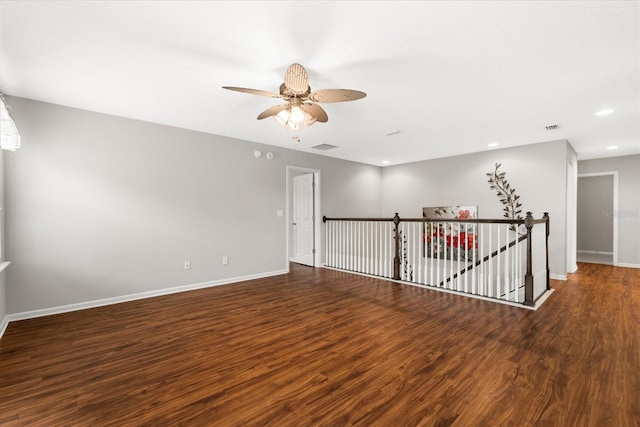 empty room with dark wood-type flooring and ceiling fan