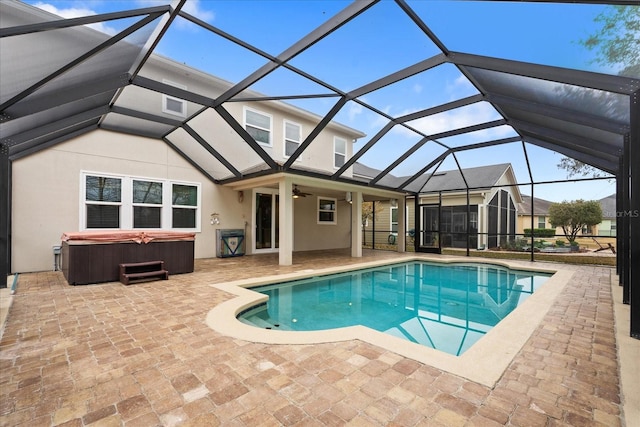 view of pool featuring a lanai, a patio area, a hot tub, and ceiling fan