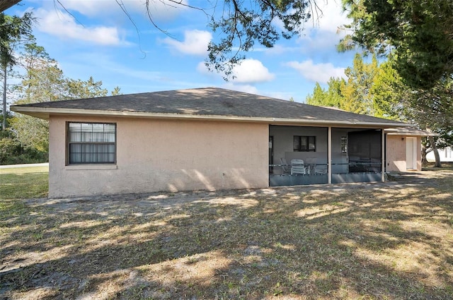 back of house featuring a yard and a sunroom