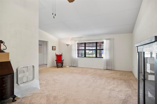 living area with ceiling fan, light carpet, and high vaulted ceiling