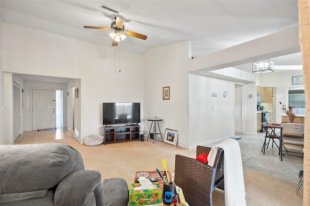 carpeted living room with lofted ceiling and ceiling fan with notable chandelier