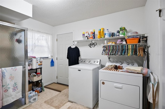 clothes washing area with washing machine and dryer and a textured ceiling