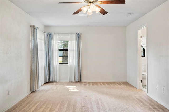 spare room with ceiling fan and light colored carpet