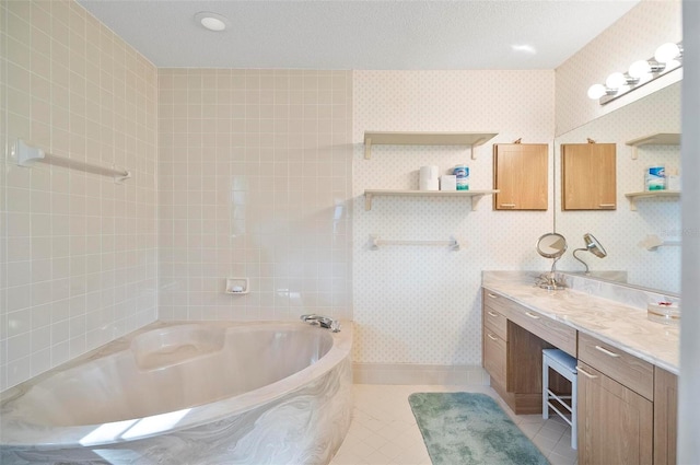 bathroom featuring tile patterned flooring, vanity, a textured ceiling, and a tub to relax in