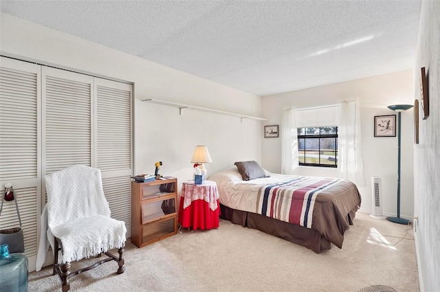 bedroom featuring light colored carpet, a closet, and a textured ceiling