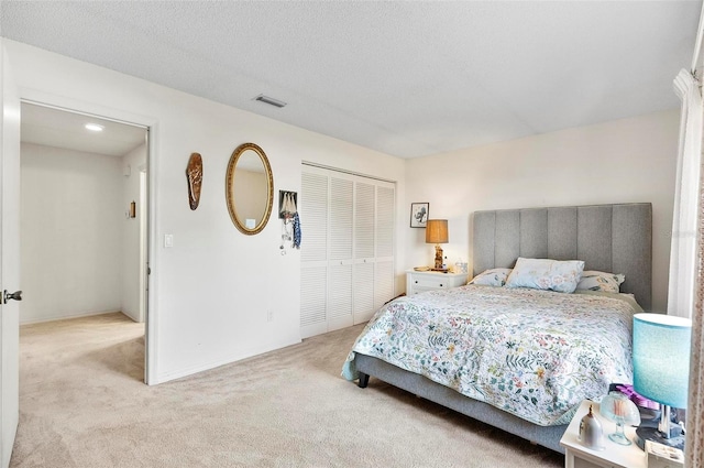 carpeted bedroom with a closet and a textured ceiling