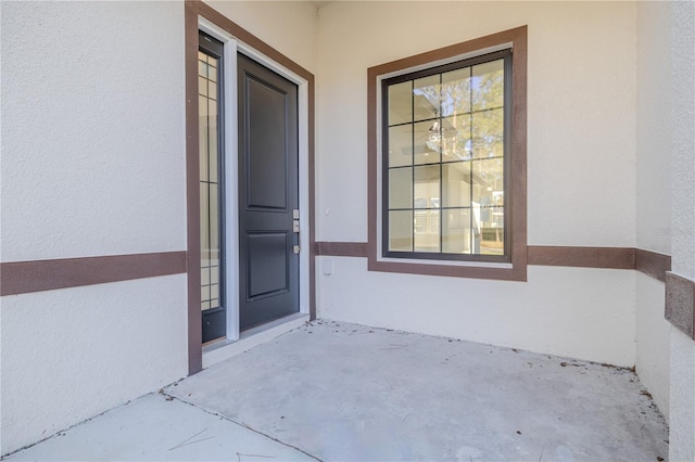 20 Pine Hill Ln, Palm Coast, FL 32164 - view of exterior entry featuring a patio and stucco siding