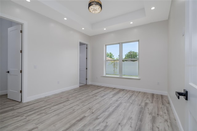 20 Pine Hill Ln, Palm Coast, FL 32164 - spare room featuring an inviting chandelier, light wood-style floors, baseboards, recessed lighting, and a raised ceiling