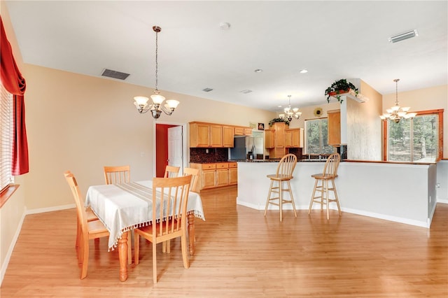 dining room featuring a notable chandelier and light hardwood / wood-style flooring