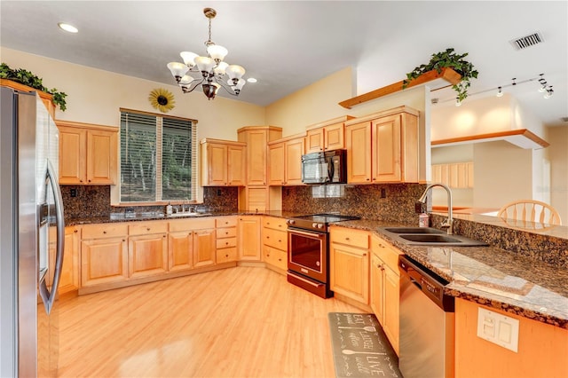 kitchen featuring appliances with stainless steel finishes, pendant lighting, sink, dark stone countertops, and light brown cabinets