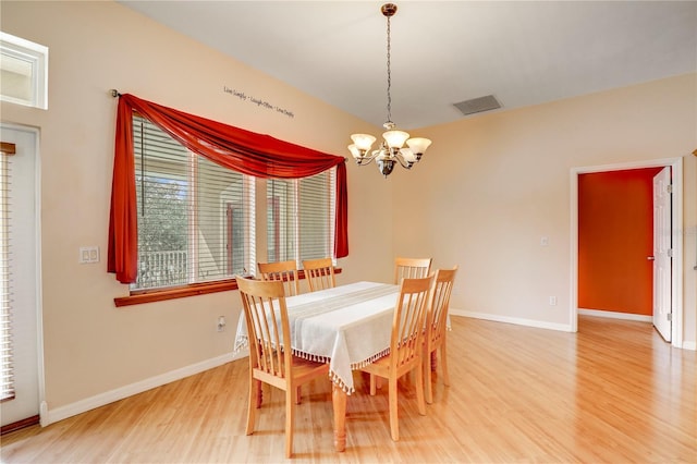 dining room with an inviting chandelier and wood-type flooring