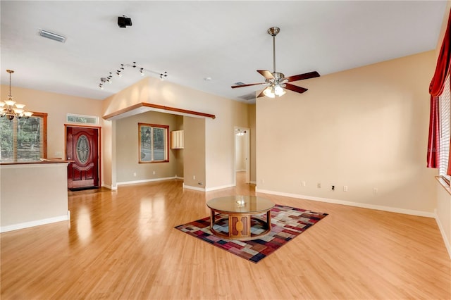 unfurnished living room featuring hardwood / wood-style flooring, ceiling fan with notable chandelier, and rail lighting