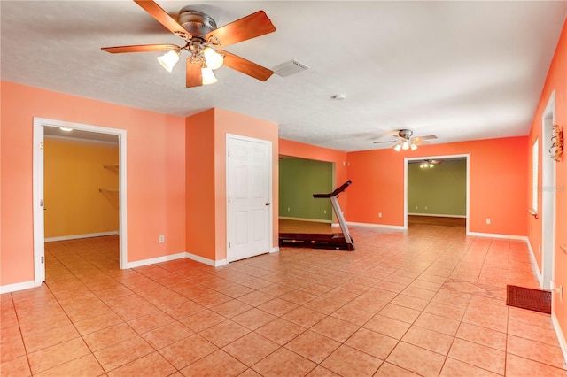 tiled empty room with ceiling fan and a textured ceiling