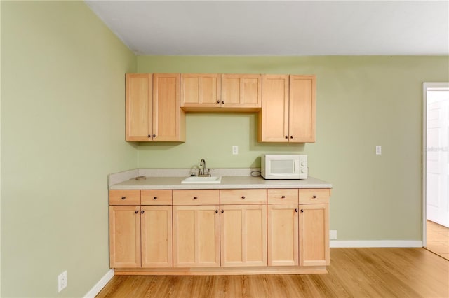 kitchen featuring sink, light wood-type flooring, and light brown cabinets