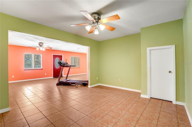 exercise room featuring ceiling fan and light tile patterned floors