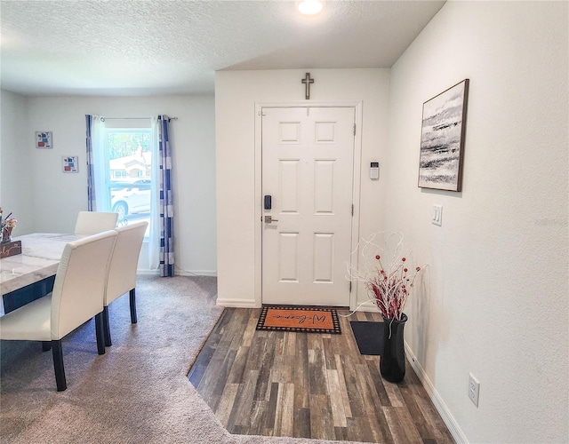 foyer with dark hardwood / wood-style flooring and a textured ceiling