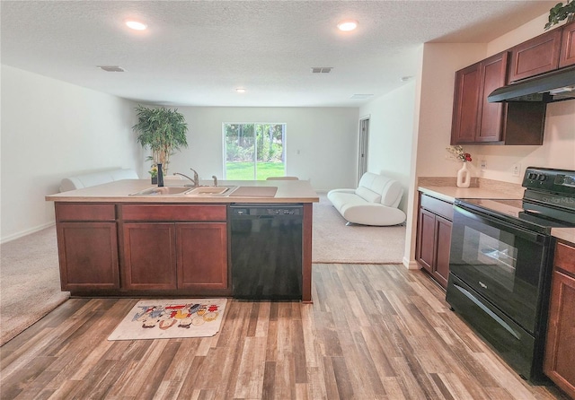 kitchen featuring sink, black appliances, light hardwood / wood-style floors, and a textured ceiling