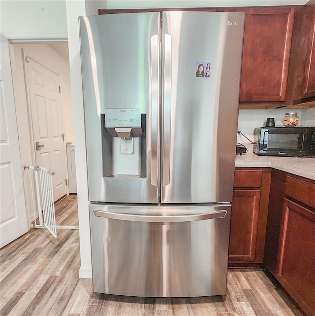 kitchen with stainless steel fridge and light hardwood / wood-style floors