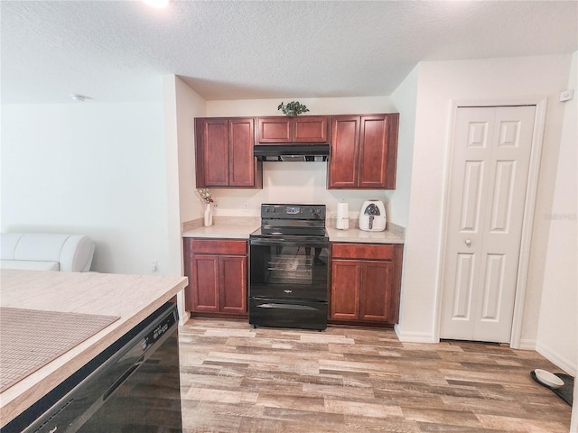 kitchen with black electric range, light hardwood / wood-style flooring, and a textured ceiling