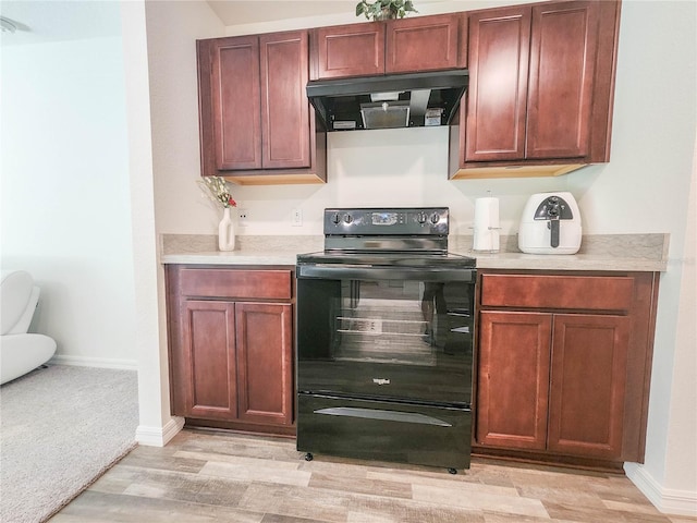 kitchen with ventilation hood, black electric range, and light hardwood / wood-style flooring