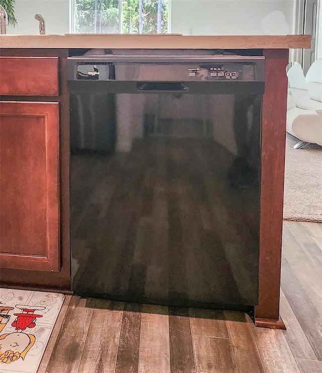 interior details featuring black dishwasher and hardwood / wood-style floors