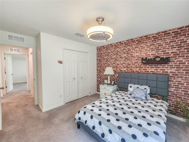 carpeted bedroom featuring brick wall and a closet