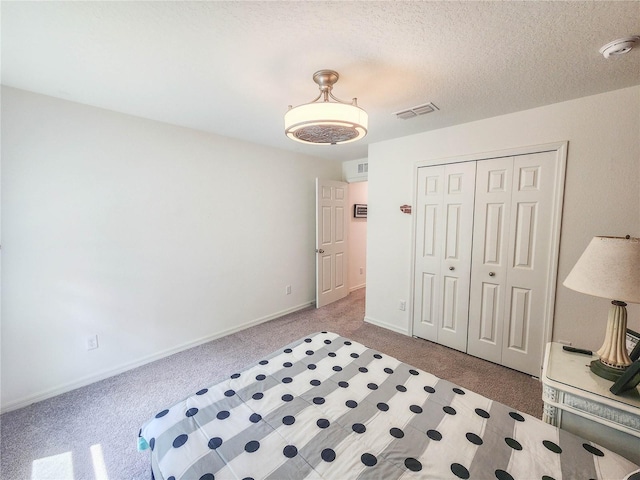 bedroom with a closet, a textured ceiling, and carpet