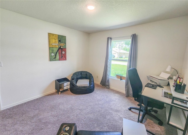 carpeted home office featuring a textured ceiling