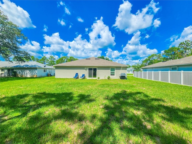 rear view of property with a yard