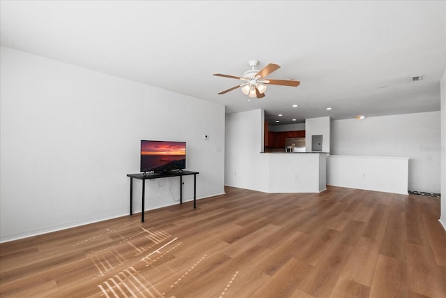 living room featuring hardwood / wood-style floors, electric panel, and ceiling fan