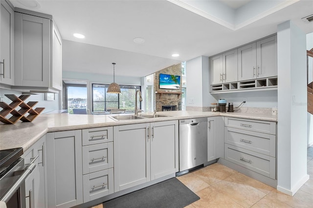 kitchen featuring a fireplace, sink, gray cabinetry, kitchen peninsula, and stainless steel appliances